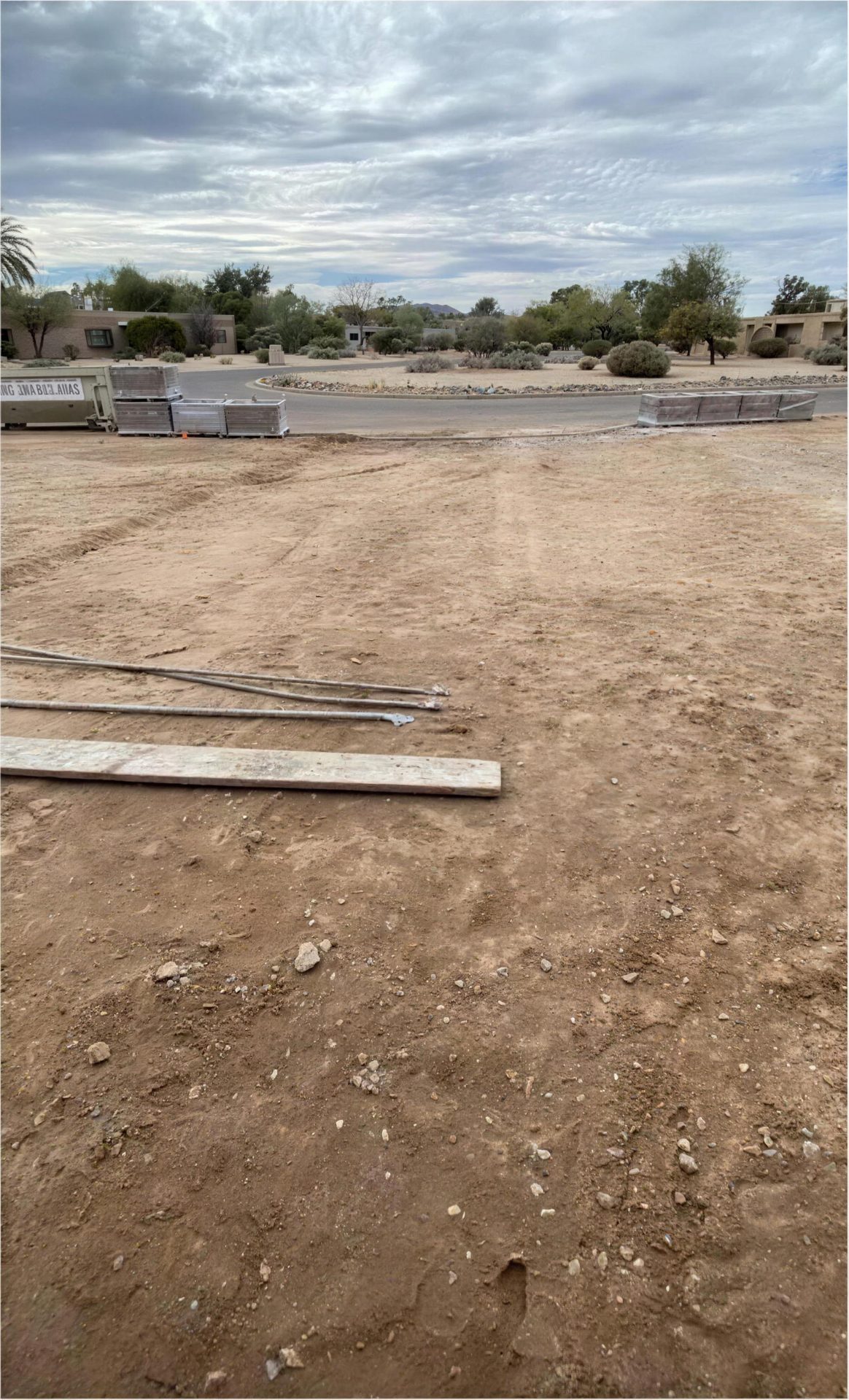 Before: graded dirt with edging stacked and ready