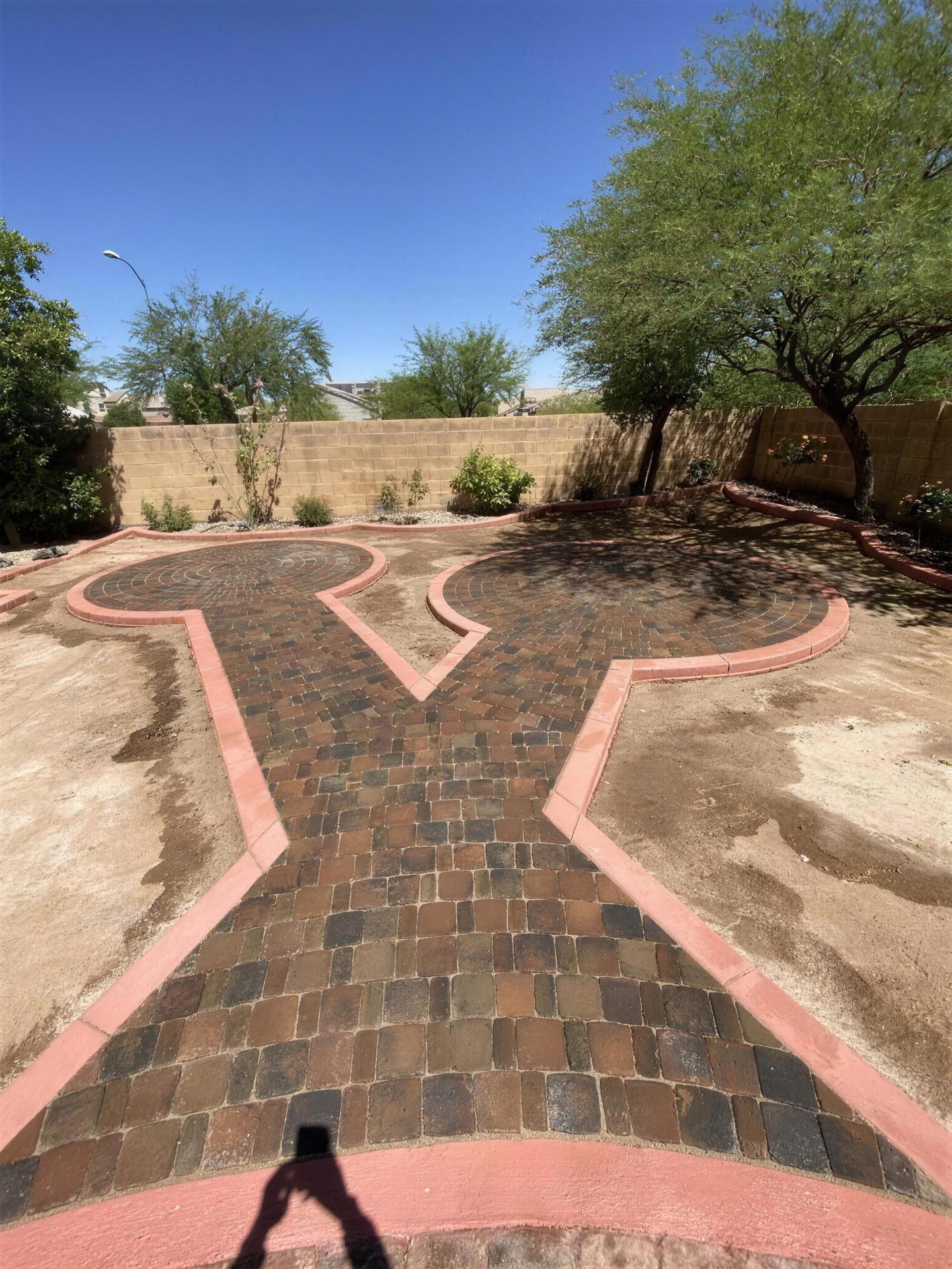 Custom paver design, twin circles and a connecting path with colored curbing