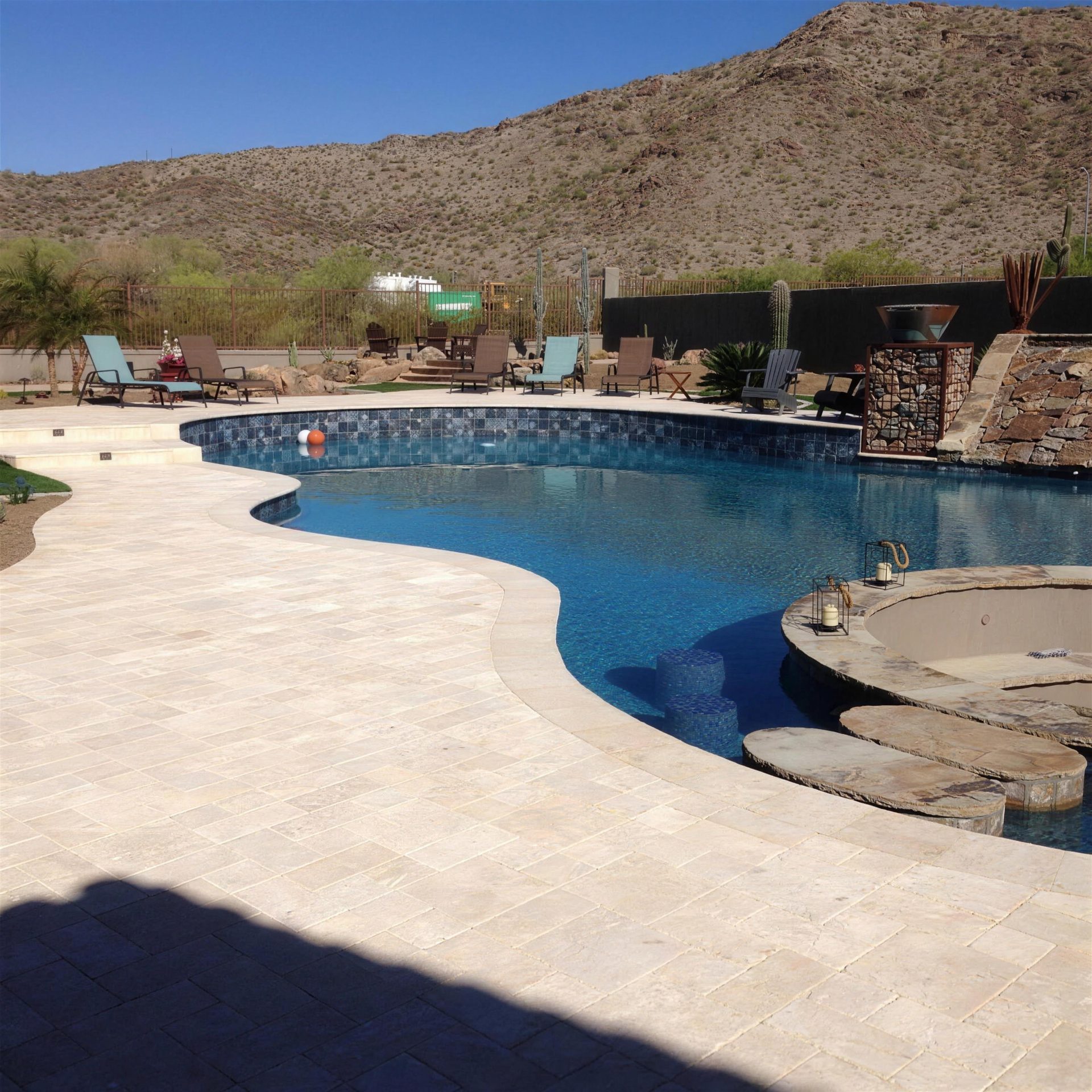Travertine pool deck with a desert mountain backdrop