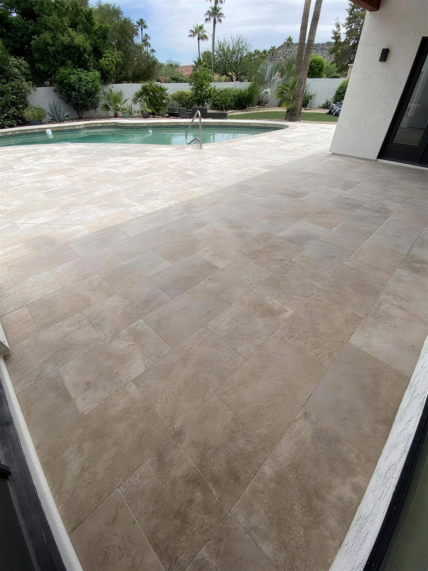 Travertine pool deck with palm trees and mountain views