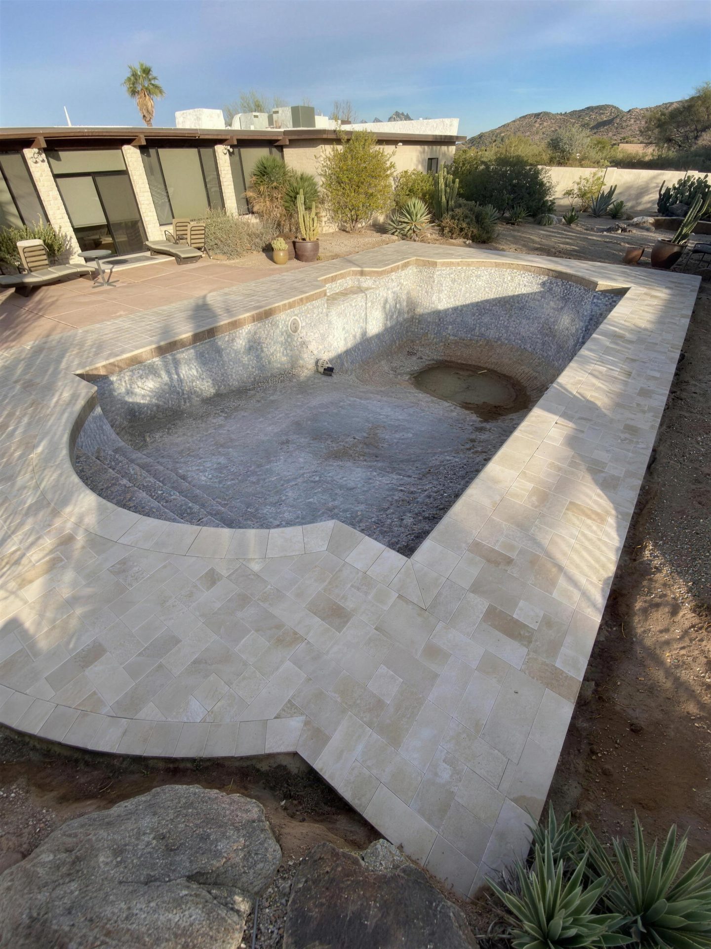 New travertine decking and coping around a pool remodel